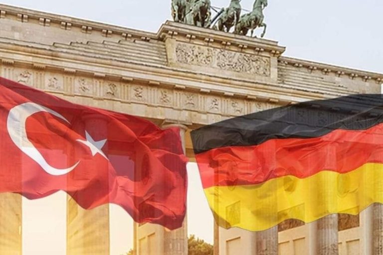 Türkische und deutsche Flaggen vor dem Brandenburger Tor im Hintergrund.