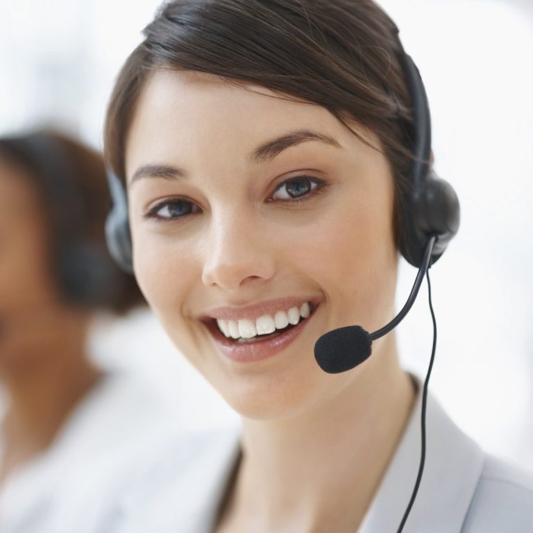 Frau mit Headset lächelt freundlich, bereit für den Kundenkontakt.