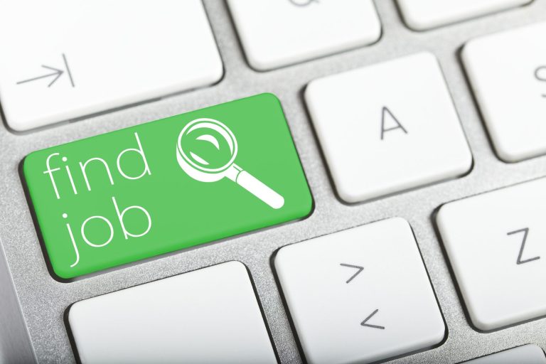 Grüne Taste auf einer Tastatur mit der Aufschrift „find job“ und Lupe.